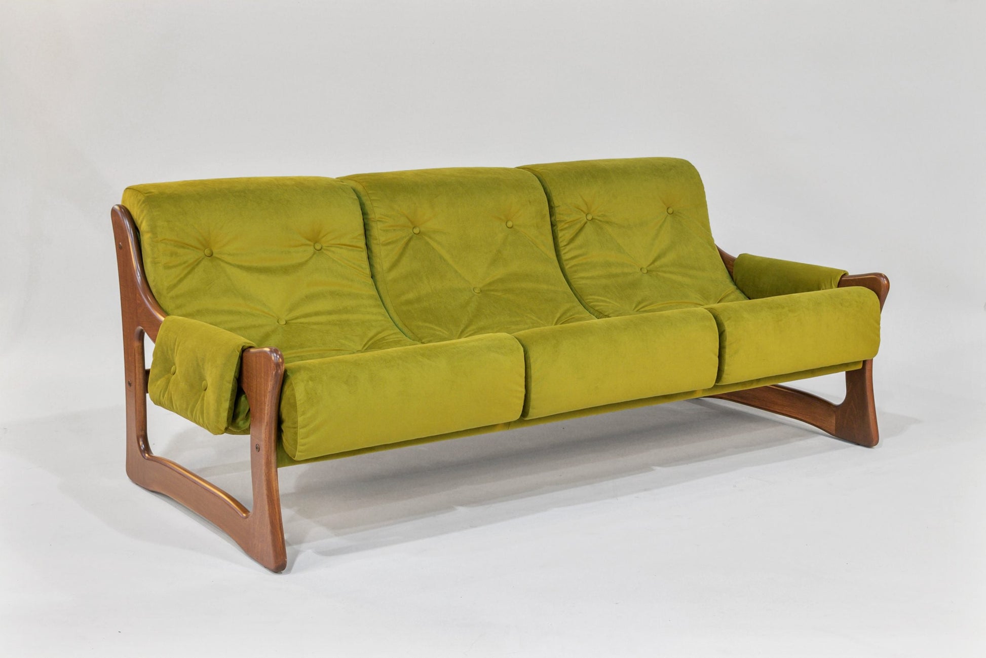 Green sofa with wooden frame on a white background