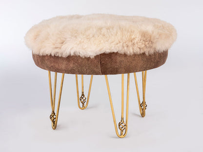 Stool with sheepskin cushion and gold hairpin legs on a white background