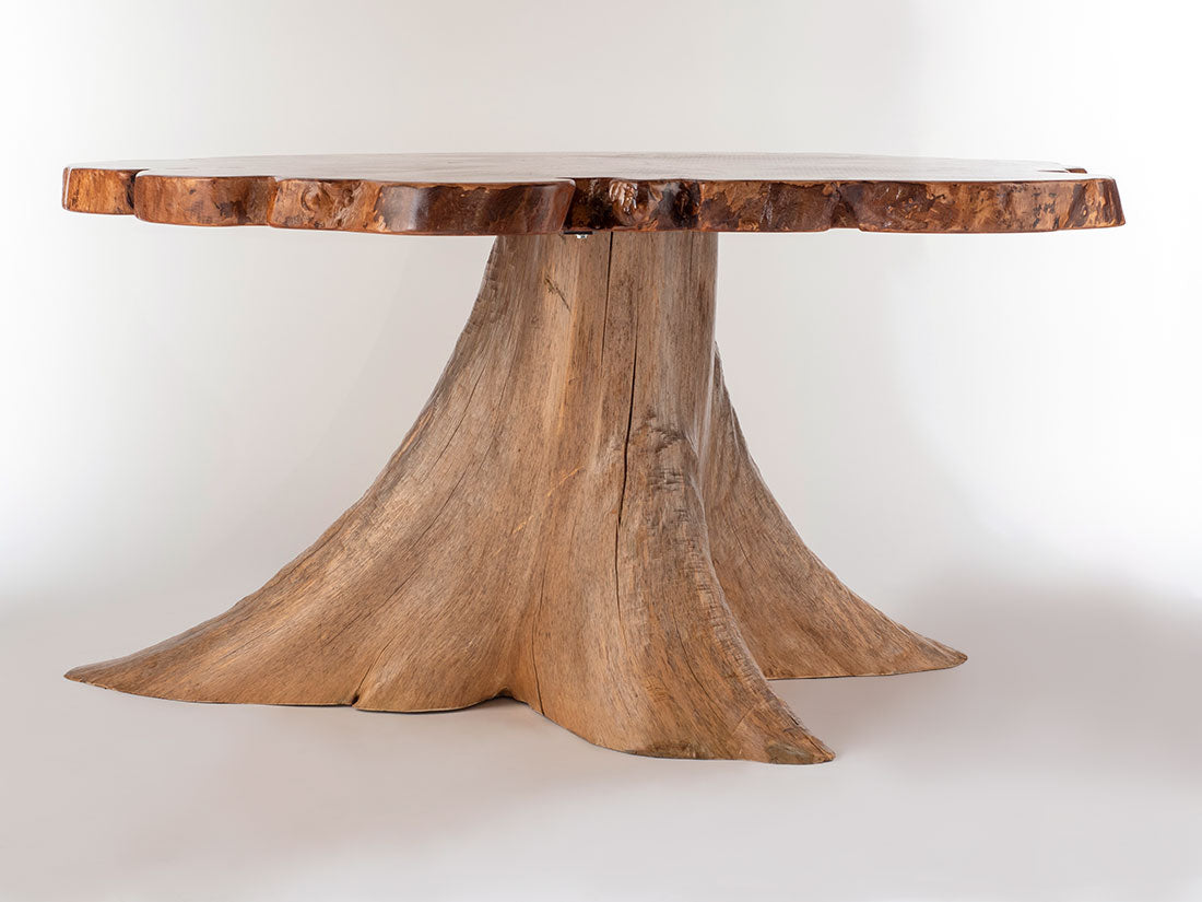 Wooden table with a natural, tree-stump-like base on a white background