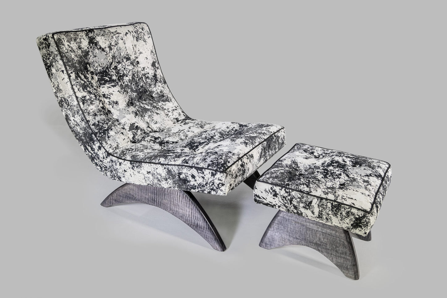 Modern lounge chair and ottoman with black and white pattern on a gray background