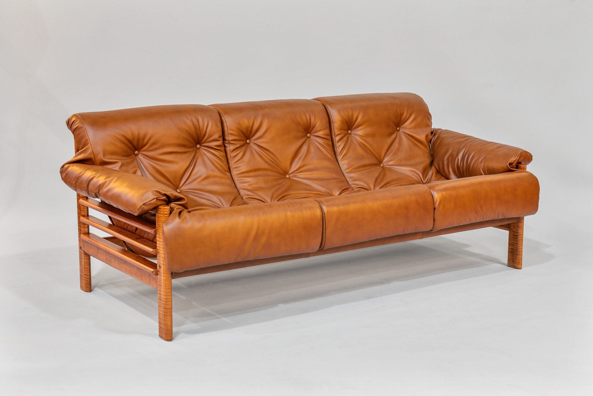 Brown leather sofa with wooden frame on a white background