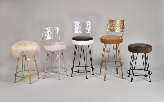 Set of five bar stools with different designs and colors on a gray background
