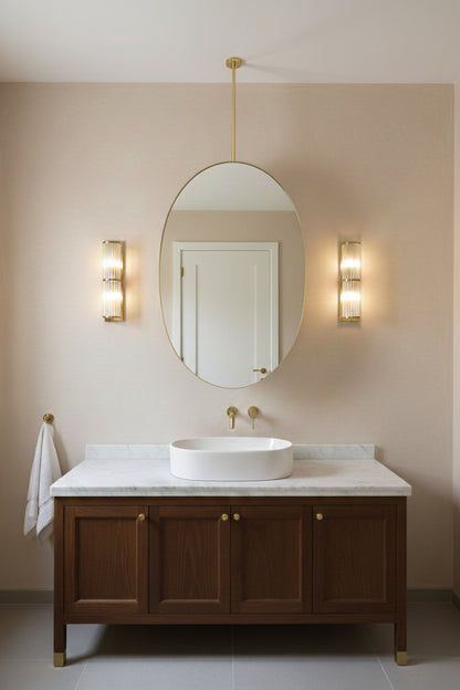 Oval hanging brass mirror above wooden vanity