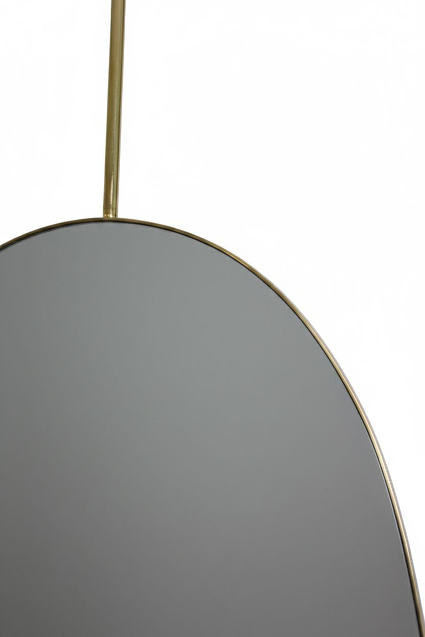 Detail of oval mirror edge with brass hanging rod