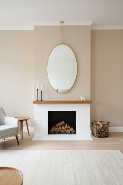 Suspended oval mirror above fireplace mantel