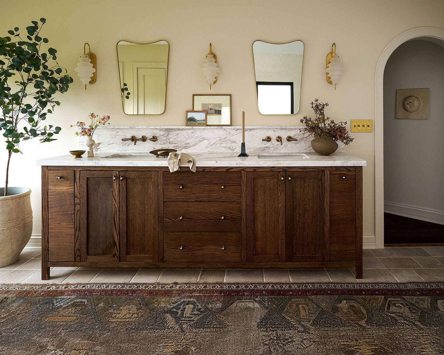 two curved brass mirror in powder room