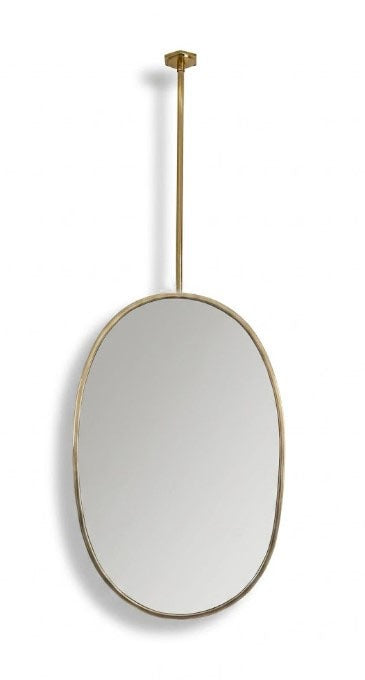 Suspended oval brass mirror with ceiling-mounted rod on white background.