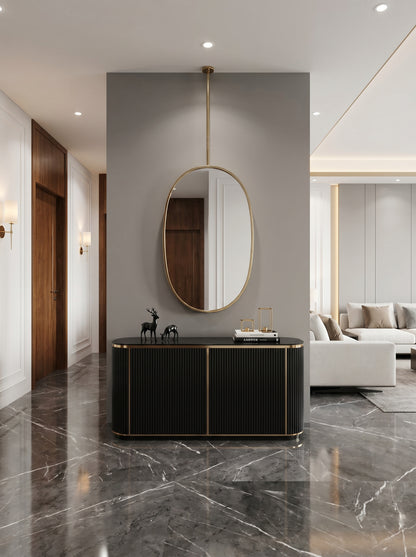 Ceiling-mounted oval brass mirror above black console table.
