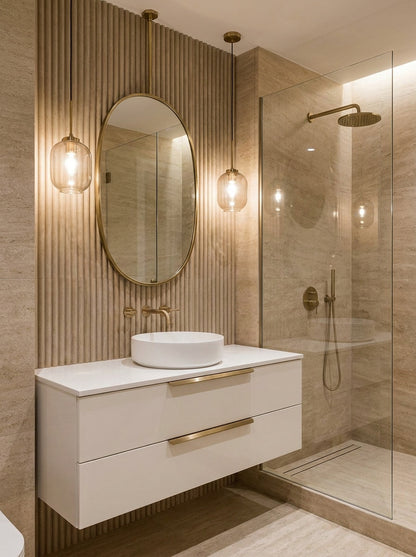 Suspended oval brass mirror above modern bathroom vanity.