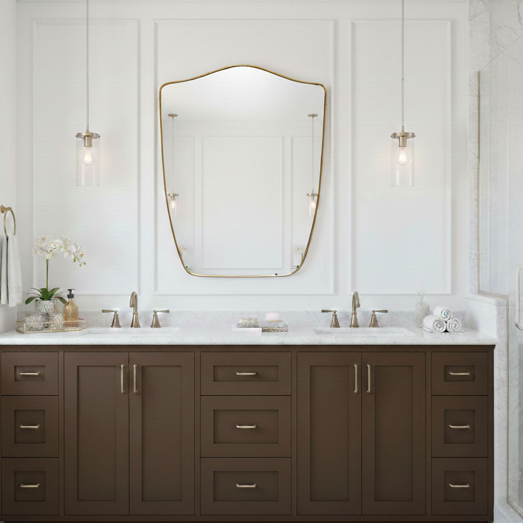 Shield wall mirror with brass frame above double bathroom vanity