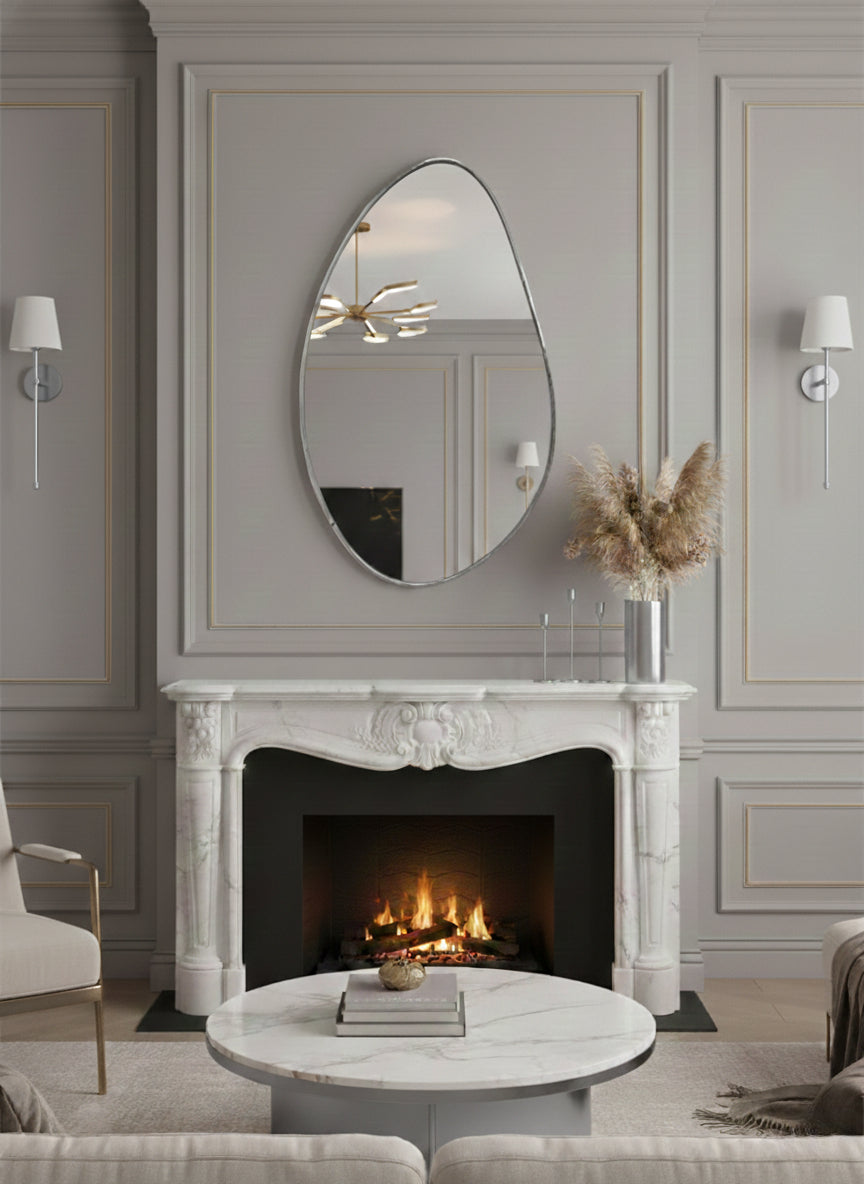 Silver asymmetrical brass mirror above fireplace.