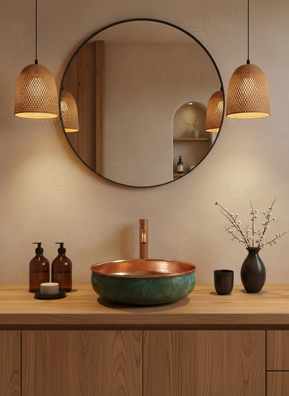 Round copper sink under black framed mirror with warm pendant lights