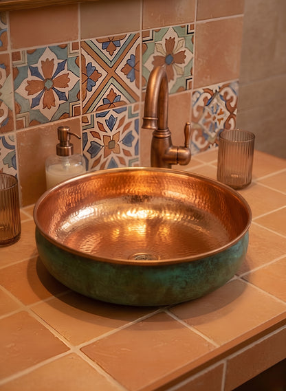 Copper sink with green exterior on patterned tile vanity