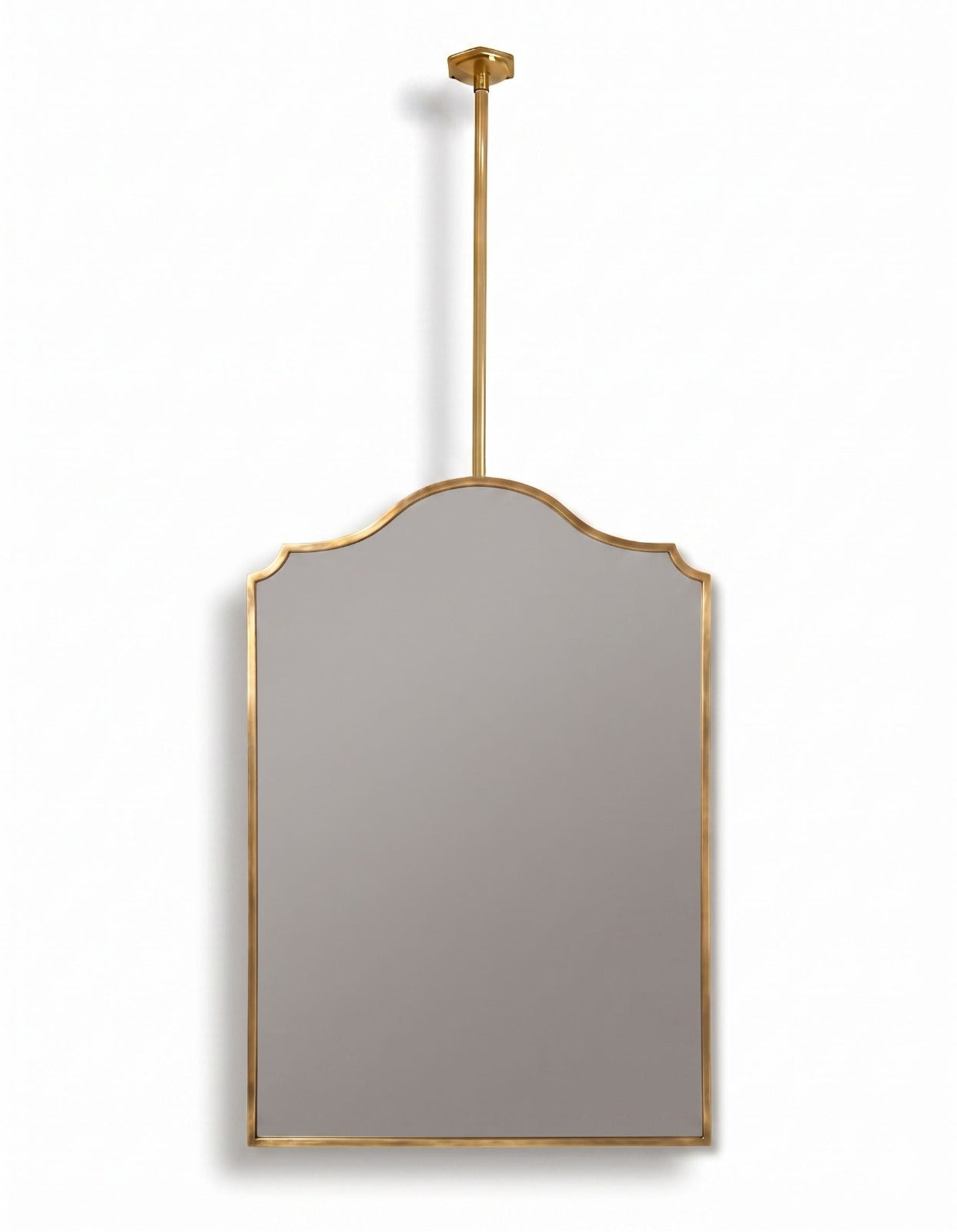 Suspended arch brass mirror with ceiling-mounted rod and gold frame on a white background.
