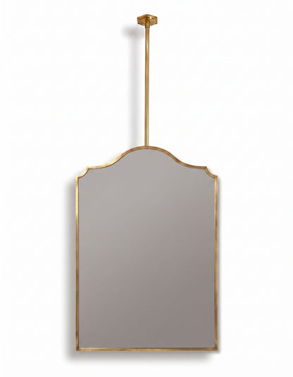 Suspended arch brass mirror with ceiling-mounted rod and gold frame on a white background.