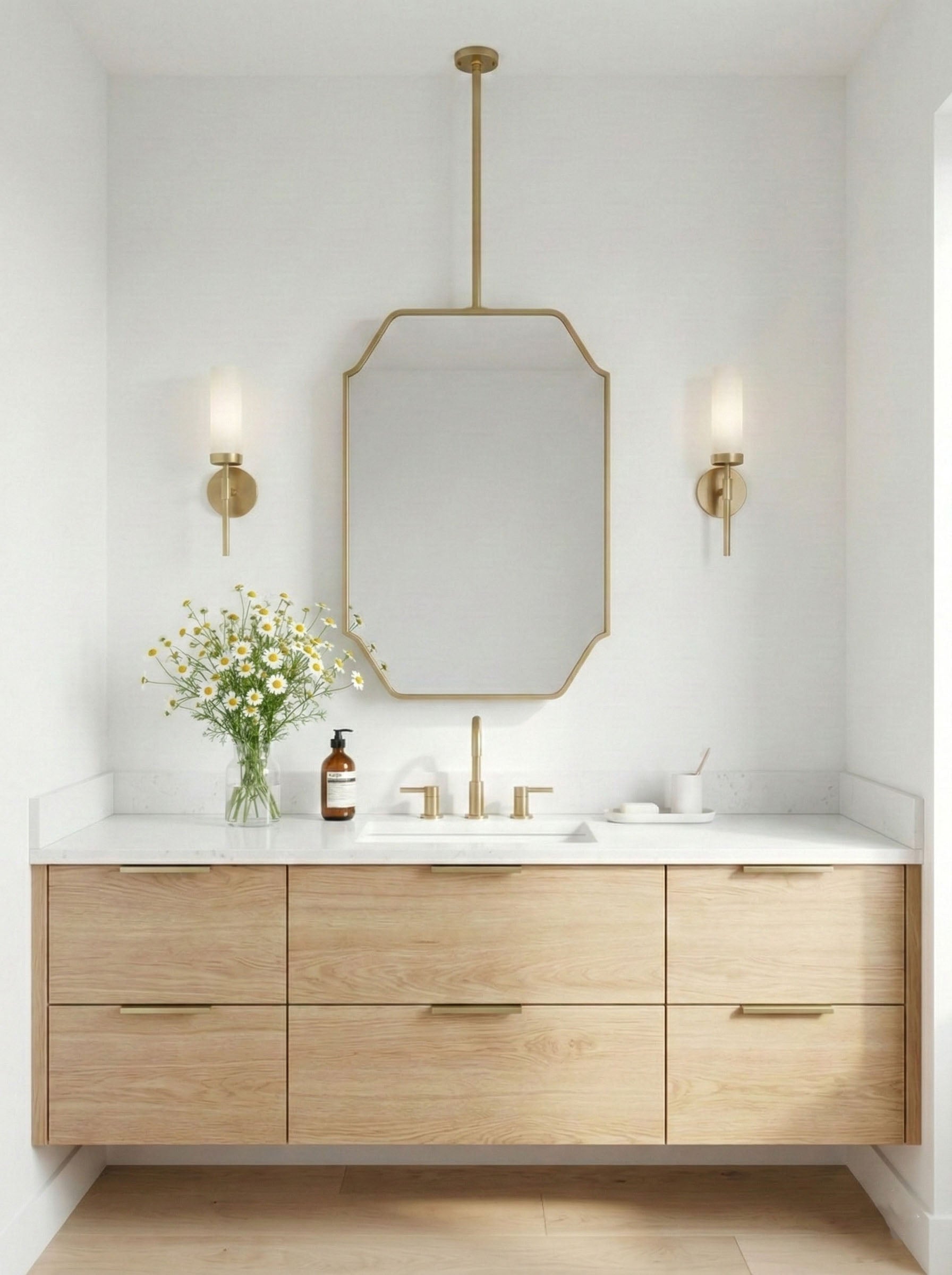  Modern brass hanging mirror over light oak double vanity with white walls.