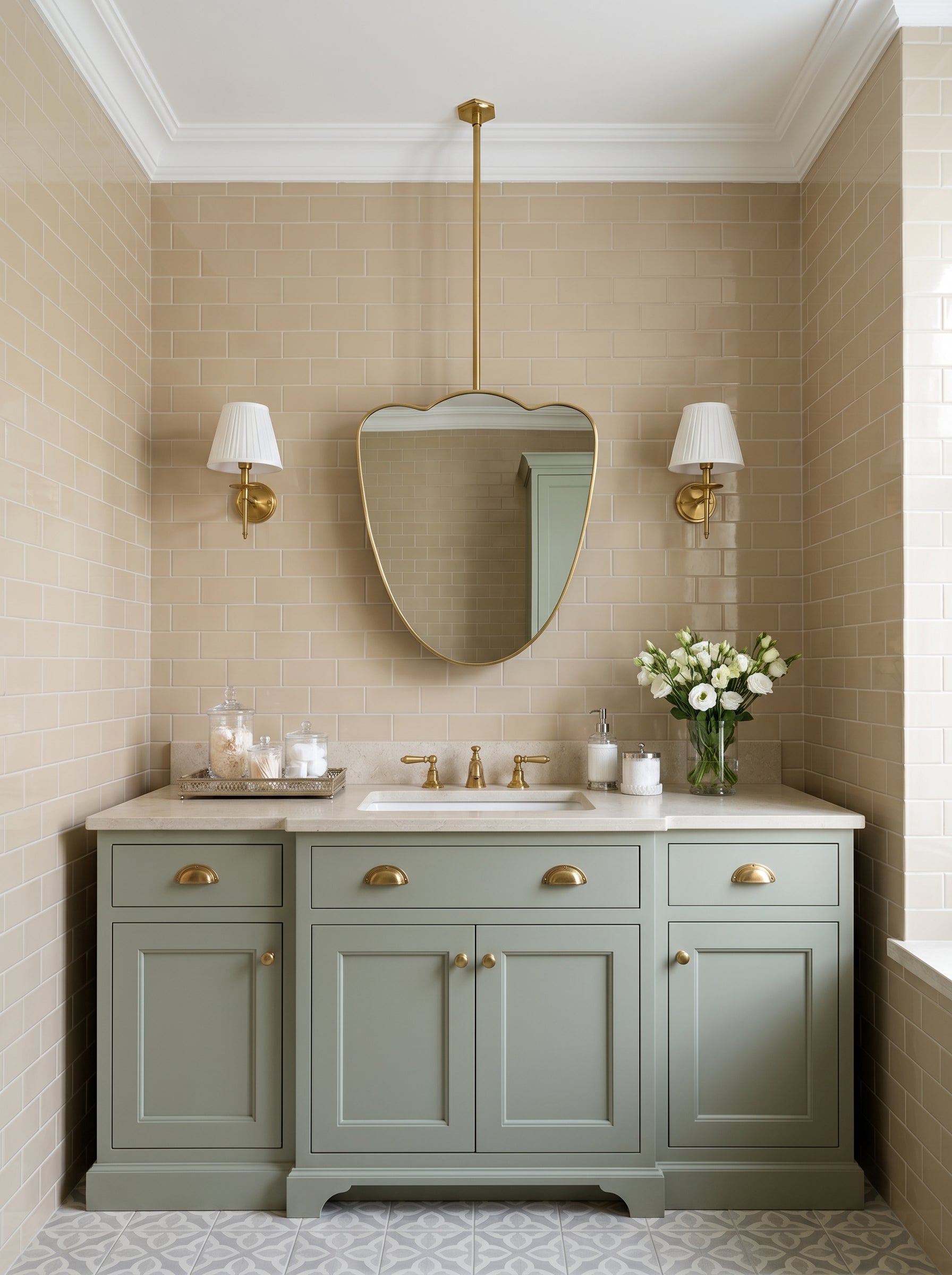 Cloud-shaped brass mirror suspended above a sage green vanity with brass wall sconces.
