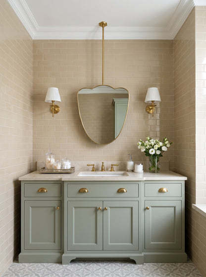 Cloud-shaped brass mirror suspended above a sage green vanity with brass wall sconces.