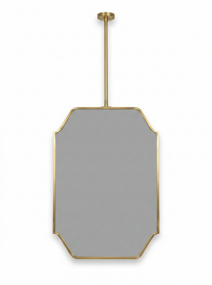 Close-up of modern suspended brass mirror with geometric art deco frame.