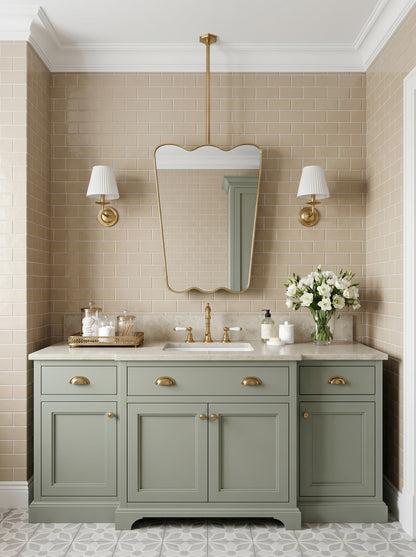 Scalloped brass hanging mirror over a classic green vanity cabinet.