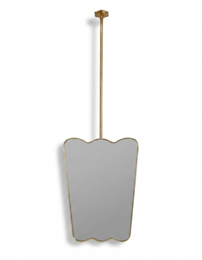 Suspended scalloped brass vanity mirror with ceiling-mounted rod and gold frame.