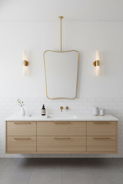 Minimalist bathroom with light wood vanity and ceiling-mounted brass mirror