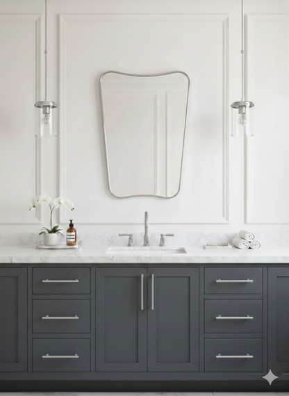 Silver irregular wall mirror above gray bathroom vanity.