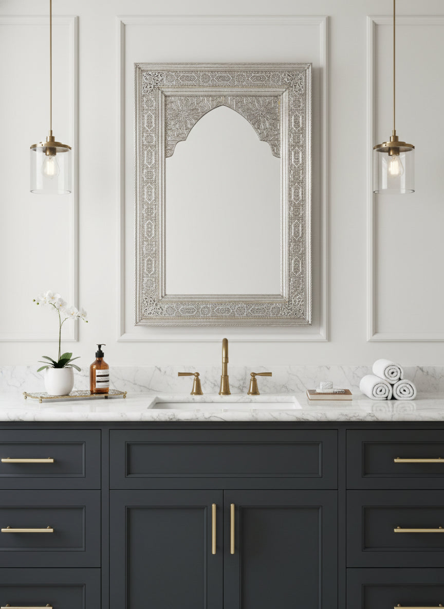 Engraved silver arched mirror above gray bathroom vanity.