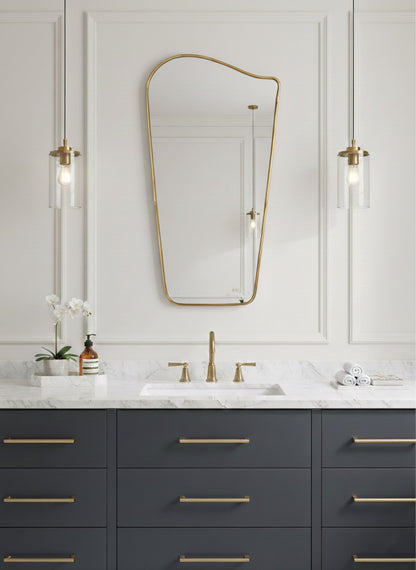 Wave brass mirror mounted over dark vanity in modern bathroom