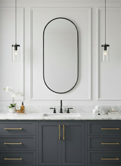 Black oval mirror above gray bathroom vanity.