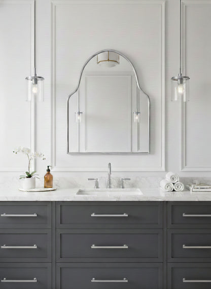 Silver brass arch mirror above marble bathroom vanity with pendant lights.