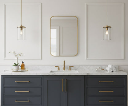Rectangular brass mirror above dark blue vanity.
