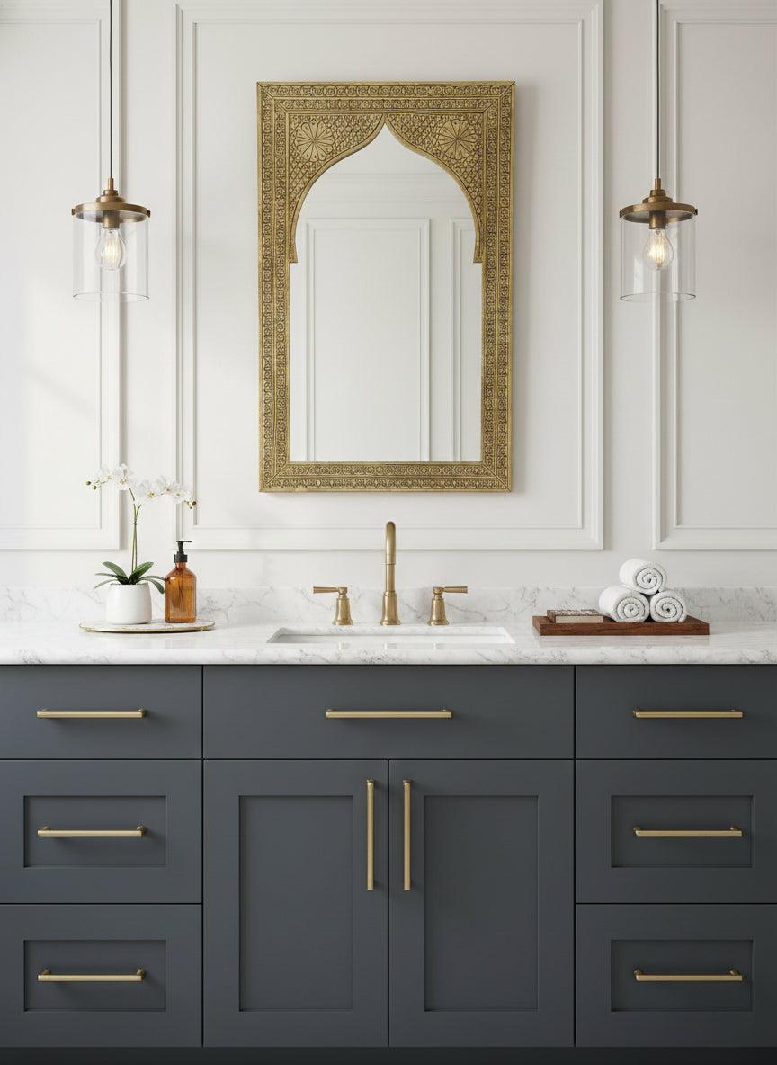 Carved arch brass mirror above a bathroom vanity