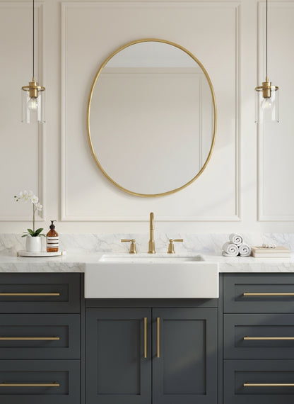 Oval brass mirror above a contemporary bathroom vanity