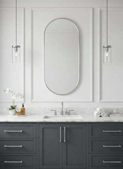 Silver capsule mirror over gray vanity with marble countertop.