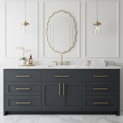 Oval wavy brass wall mirror above gray vanity in elegant bathroom.
