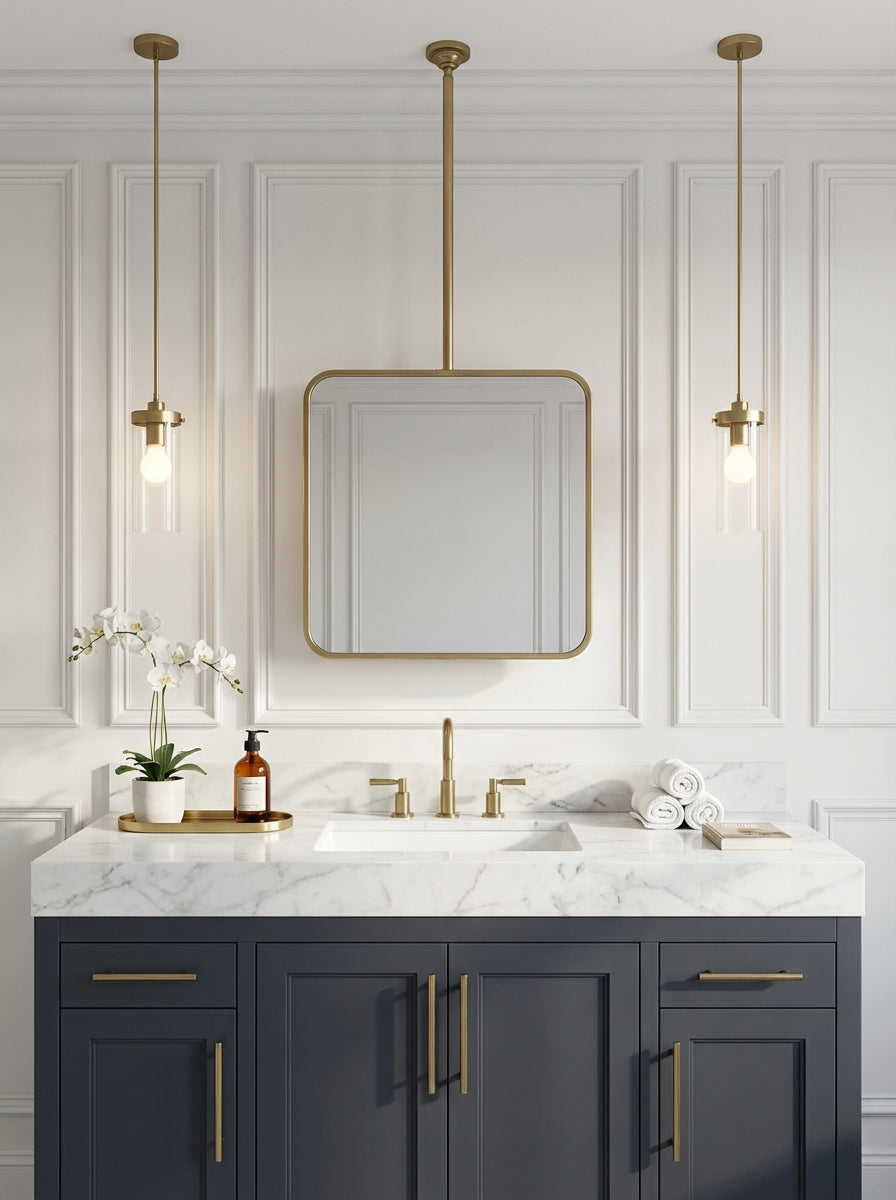 Modern suspended square brass mirror above navy vanity with marble top.