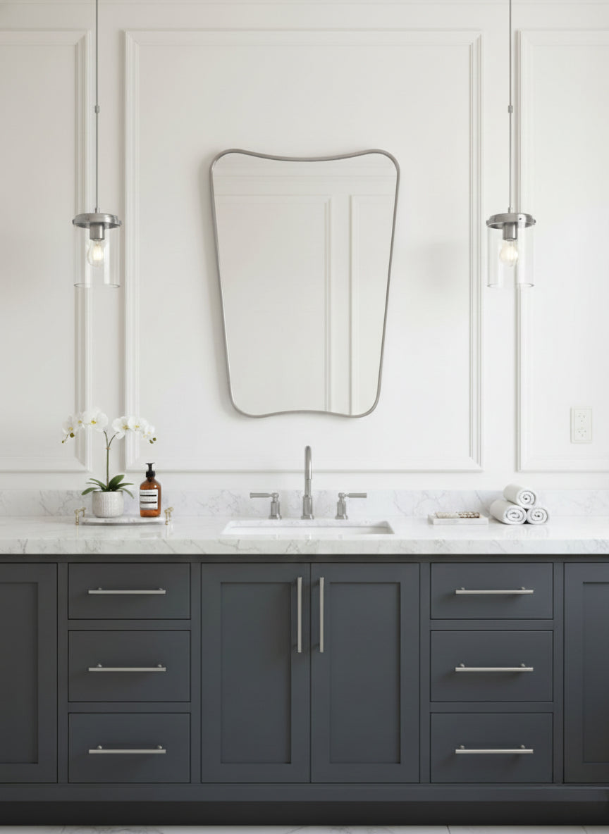 Silver brass mirror over gray vanity with marble countertop.