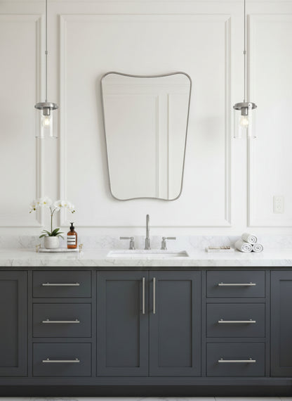 Silver brass mirror over gray vanity with marble countertop.
