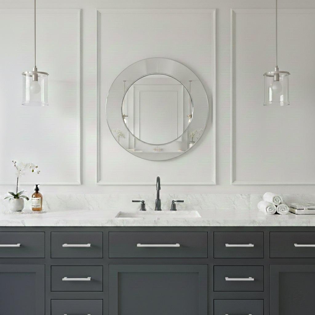 Round silver brass mirror above gray vanity with marble countertop.
