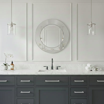 Round silver brass mirror above gray vanity with marble countertop.
