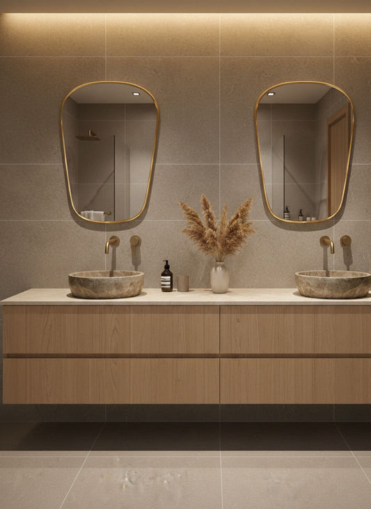 Pair of shield brass wall mirrors above double vanity