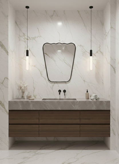 Wavy brass mirror above marble vanity