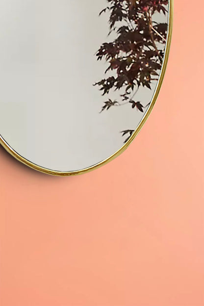 a round mirror on a pink wall