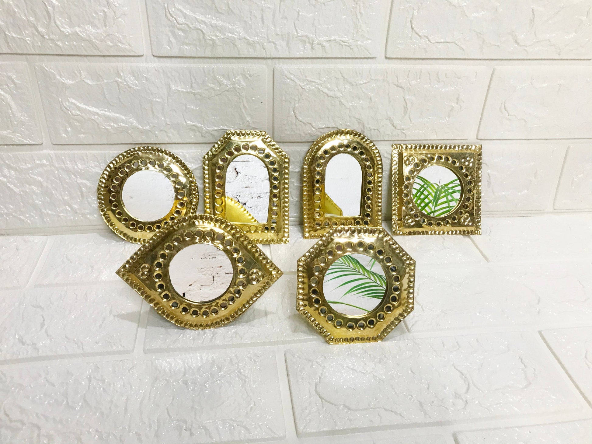 a group of four mirrors sitting on top of a wall