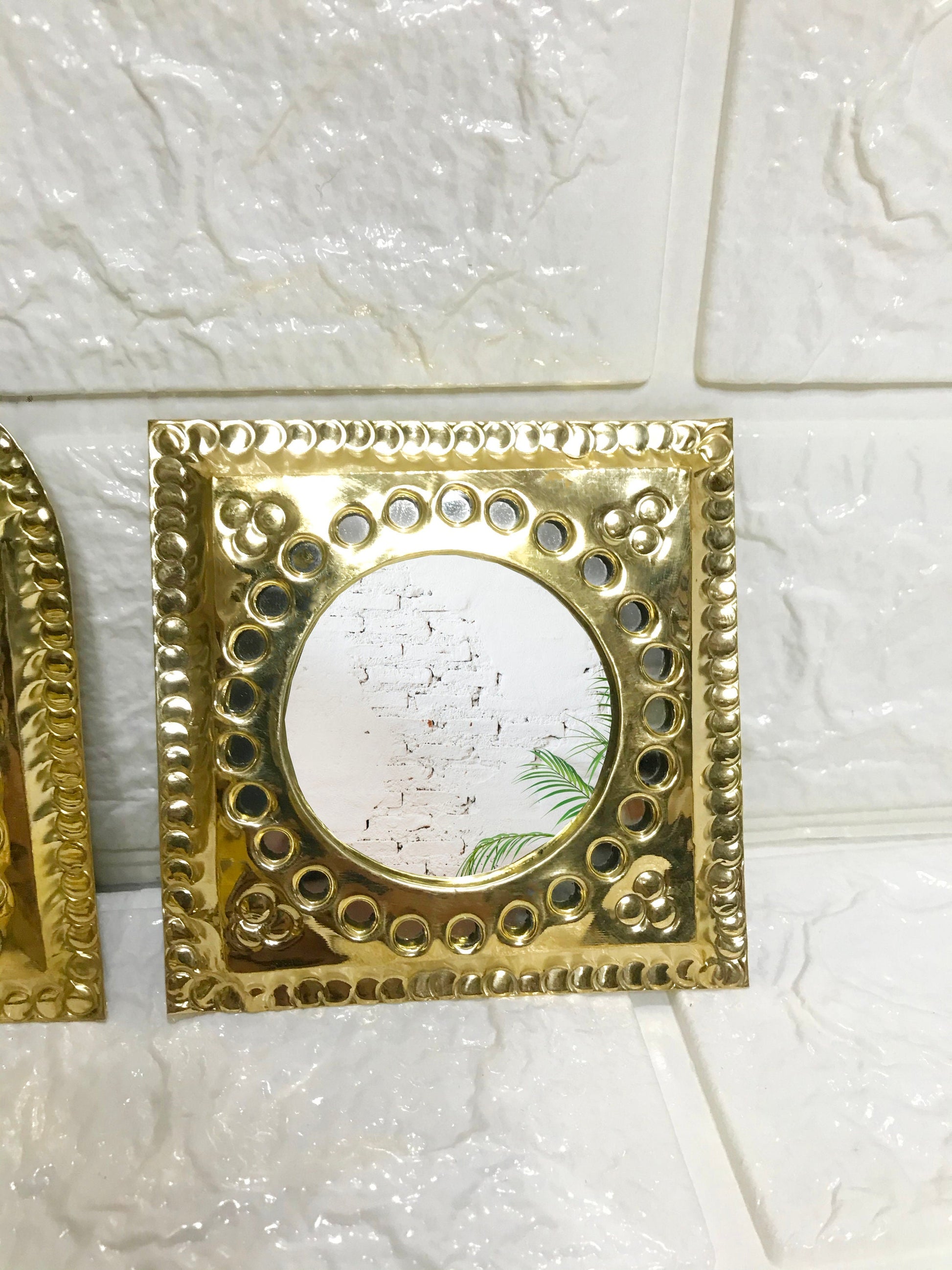 a couple of gold frames sitting on top of a tiled wall