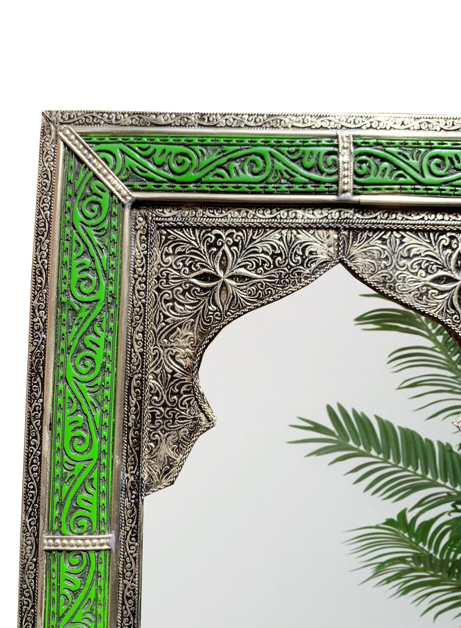 a mirror with a green and silver design on it