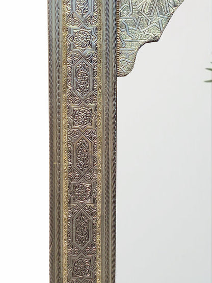 a tall mirror with a design on it