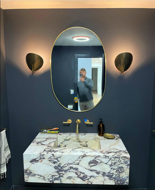 a man taking a picture of himself in a bathroom mirror