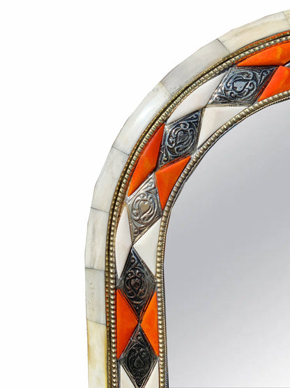 a decorative mirror with an orange and white border